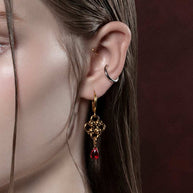 gold knotted dangle earrings with red drop